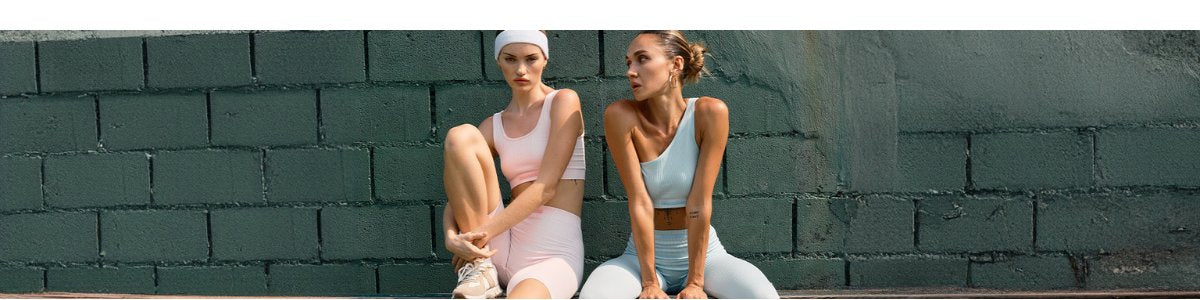 Sporty woman in stylish womens gym wear holds a tennis racket, ready for a match in her fashionable dress.